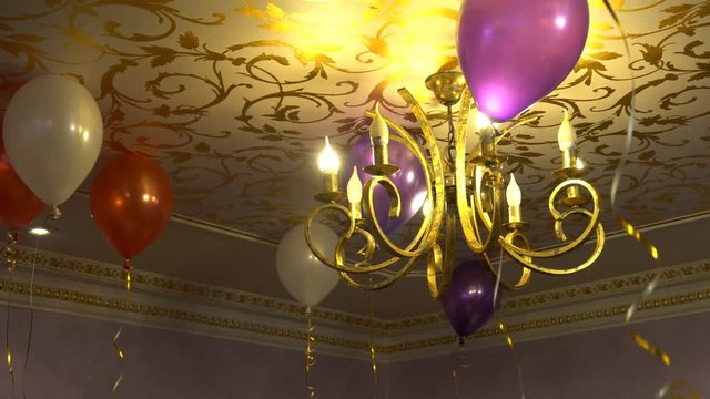 White red and purple balloons floating on the ceiling.