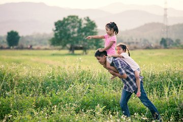 Naklejka na ściany i meble Father and daughter having fun and playing together in the cornfield and child riding on father's back and shoulder in vintage color tone