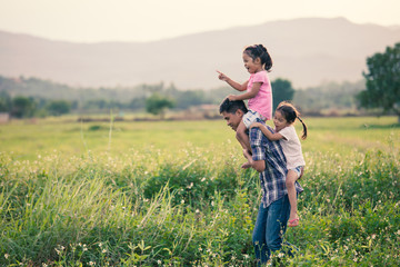 Father and daughter having fun and playing together in the cornfield and child riding on father's back and shoulder in vintage color tone
