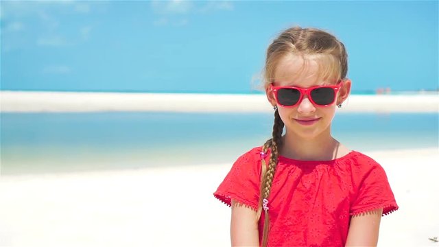 Portrait of adorable little girl at beach during summer vacation. SLOW MOTION
