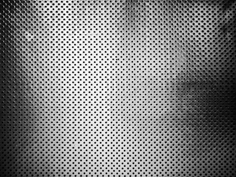 Perforated metal plate texture background vintage black and white tone filter