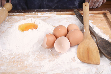 A dough with eggs and utensils.