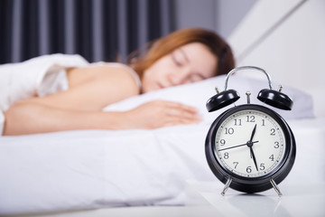 clock with woman sleeping on bed