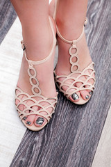 Photo of beautiful female legs in summer shoes closeup
