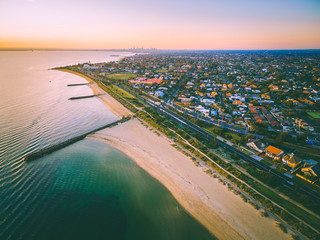 Aerial view of Port Phillip Bay and Melbourne coastline suburban living quarters at dusk with...