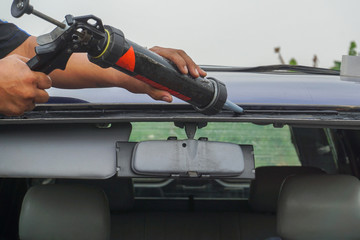 Glazier using tools repairing to fix crack broken windshield, windscreen on the front window glass...