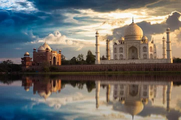 Fotobehang Artistiek monument Taj Mahal met een humeurige zonsonderganghemel aan de oevers van de rivier de Yamuna. Taj Mahal is een witmarmeren mausoleum dat is aangewezen als UNESCO-werelderfgoed in Agra, India.