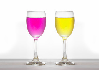 2 color alcohol drinks, yellow and pink And a reflection, set in the studio.