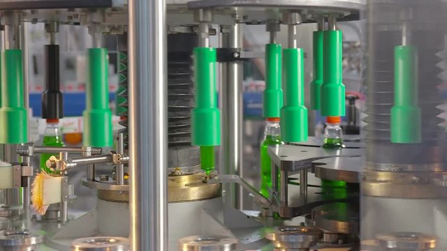 Automatic conveyor line for filling water and lemonade in a plastic bottle. Bottling of lemonade in plastic bottles. Lemonade bottle conveyor industry. 