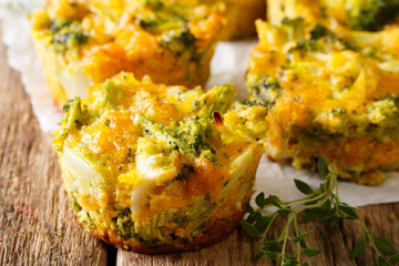 Freshly baked broccoli muffins with cheese and thyme close-up on parchment. horizontal