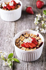 Strawberry blackberry crumble with oatmeal crispy crust on vintage rustic wooden table. Healthy breakfast. Summer baking. Diet. Selective focus 