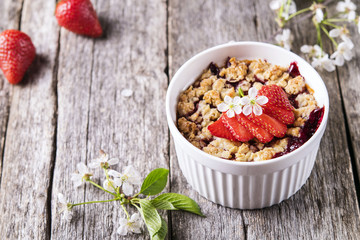 Strawberry blackberry crumble with oatmeal crispy crust on vintage rustic wooden table. Healthy breakfast. Summer baking. Diet. Selective focus 