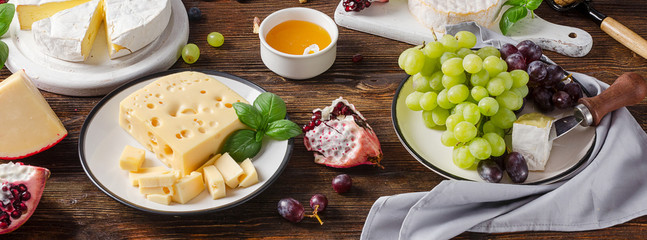 Cheeses with grapes  on a wooden table