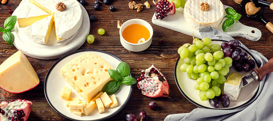Cheeses with grapes  on dark wooden table