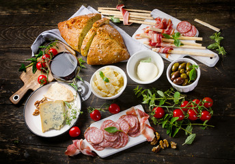 Different meat and cheese products with wine glas