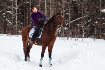 Fototapeta na wymiar Woman with red hair and big horse outdoor in winter