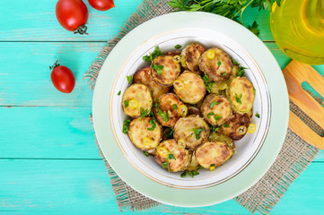 Fried slices of young zucchini with hot pepper, greens on a plate on a wooden background. Top view. Close up. Vegetarian cuisine. Vegetable dish.