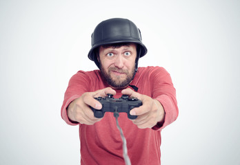 Portrait of adult bearded man in helmet holding joystick and playing videogames. File contains a path to isolation
