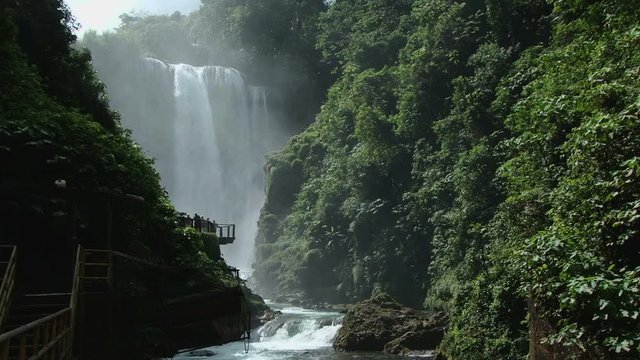 Wide shot of the Pulhapanzak waterfall in Honduras. Tourists at view point taking photos