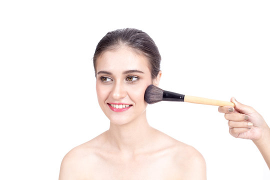 Makeup artist applies brushed at woman face. Beautiful woman face. Perfect makeup, isolated on white background, 20s year old.