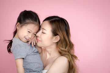 woman hodling kid with happy emotion, isolated on pink background.