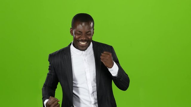 Guy in the strict black suit is happy with his victory. Green Screen