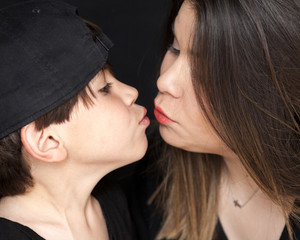 Portrait of older sister with her younger brother, black background