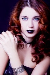 Fototapeta premium Pretty female fashion model posing in studio with dark gothic make up
