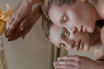 portrait of the young blonde attractive woman with the fashion alien gold make up laying with the...
