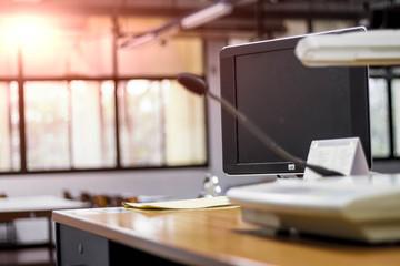 empty it classroom with program code on projector screen and modern laptop computers on table