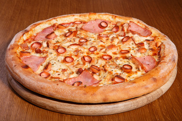 Italian pizza on the table, pepperoni, spices, tomatoes, cheese