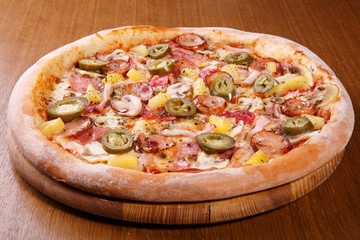 Italian pizza on the table, pepperoni, spices, tomatoes, cheese