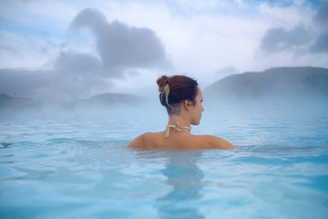 Woman enjoys spa in geothermal hot spring - Powered by Adobe