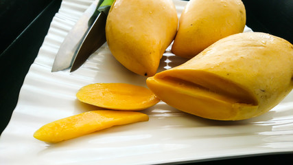 Ripe yellow mango on a black background