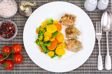 Pieces of fried chicken fillet in batter and mix of stewed veget