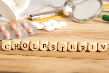Stethoskop, verschiedene Tabletten und das Wort Cholesterin
