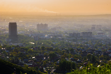 Naklejka premium Almaty city in the fog in sunset with smog and dust in the air, Kazakhstan