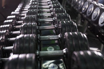 Obraz na płótnie Canvas Rows of dumbbells in the gym close-up