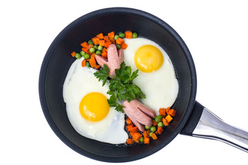 Fried eggs with sausage and vegetables in frying pan on white ba