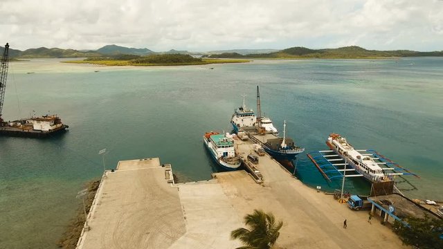 Cargo and passenger port with barges and cargo ships on tropical island. Aerial view:passenger ferry terminal Dapa city .Ferries for transport vehicles and passengers in the port. Philippines, Siargao