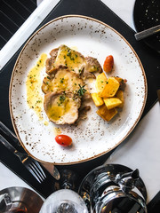 Baked potatoes and slices of beef in sauce