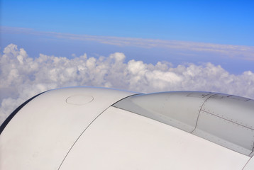 Fototapeta na wymiar Aircraft engines on blue sky with clouds background - on the airpalne view