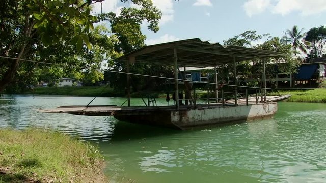 The small hand-cranked ferry crossing the Mopan river to pick up tourists and car, Belize