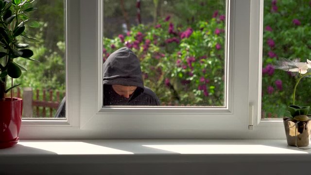 burglar breaks into a house through the window