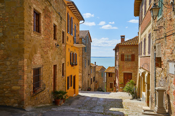 Fototapeta na wymiar Beautiful narrow alley with traditional historic houses at old city in Tuscany