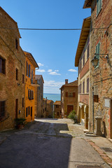 Beautiful narrow alley with traditional historic houses at old city in Tuscany