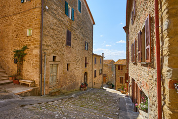 Beautiful narrow alley with traditional historic houses at old city in Tuscany
