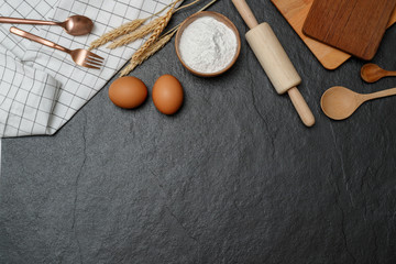 Top view kitchen utensils and baking ingredients mockup on dark border background  with notebook and pencil.