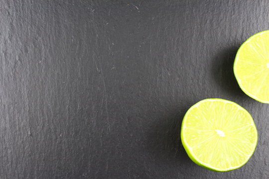 fresh lime fruit on a slate plate food background texture
