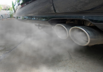Incomplete combustion creates poisonous carbon monoxide form exhaust pipe of black car, air...